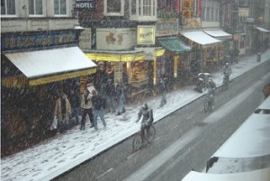 Snow does not deter pedestrians or cyclists in Amsterdam. 